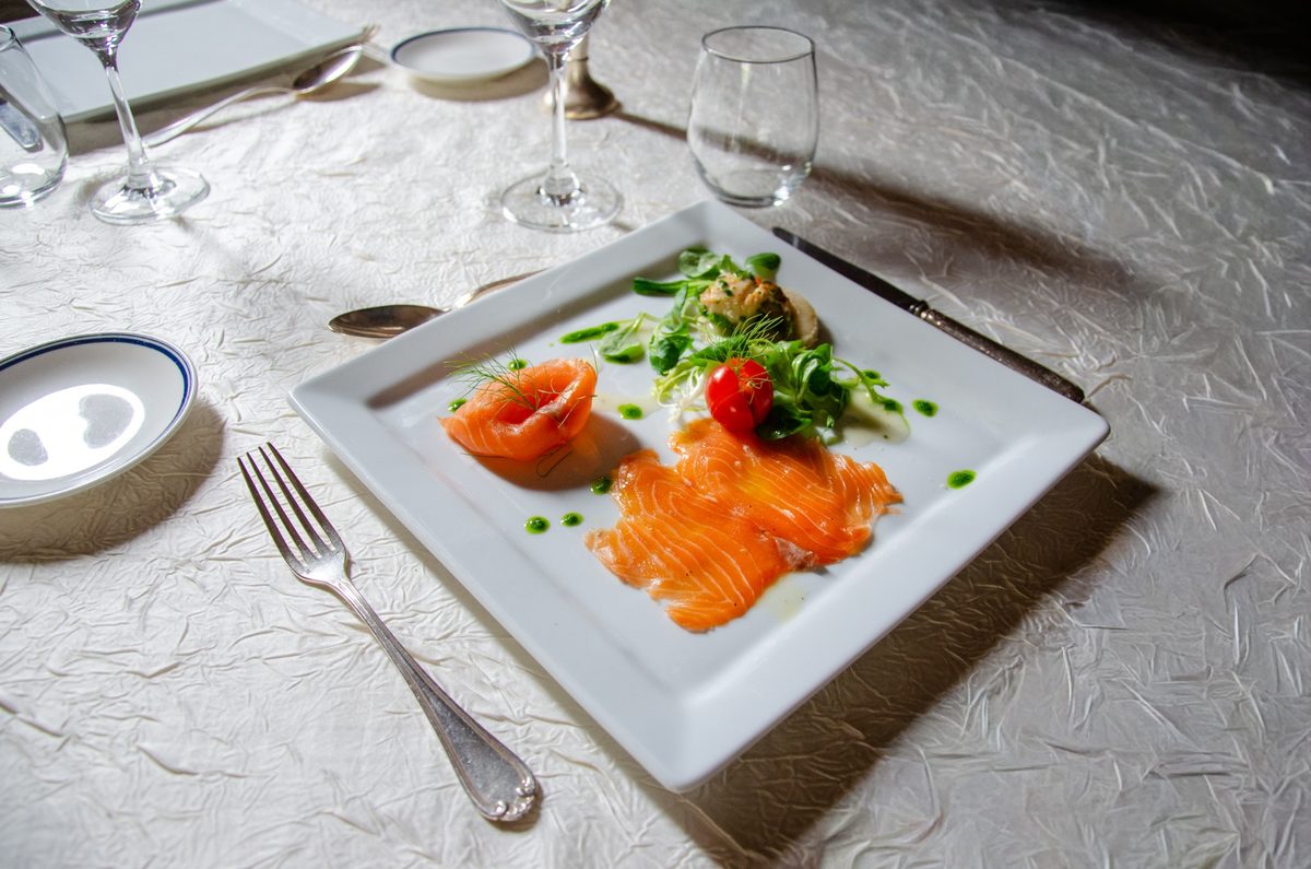 Assiette de saumon fumé dressée sur une table de restaurant