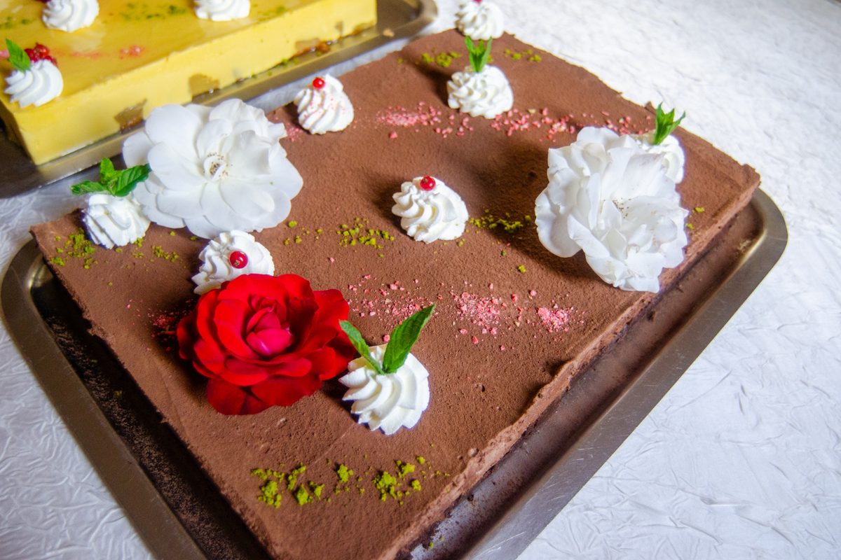 Gâteau au chocolat décoré de fleurs et de chantilly