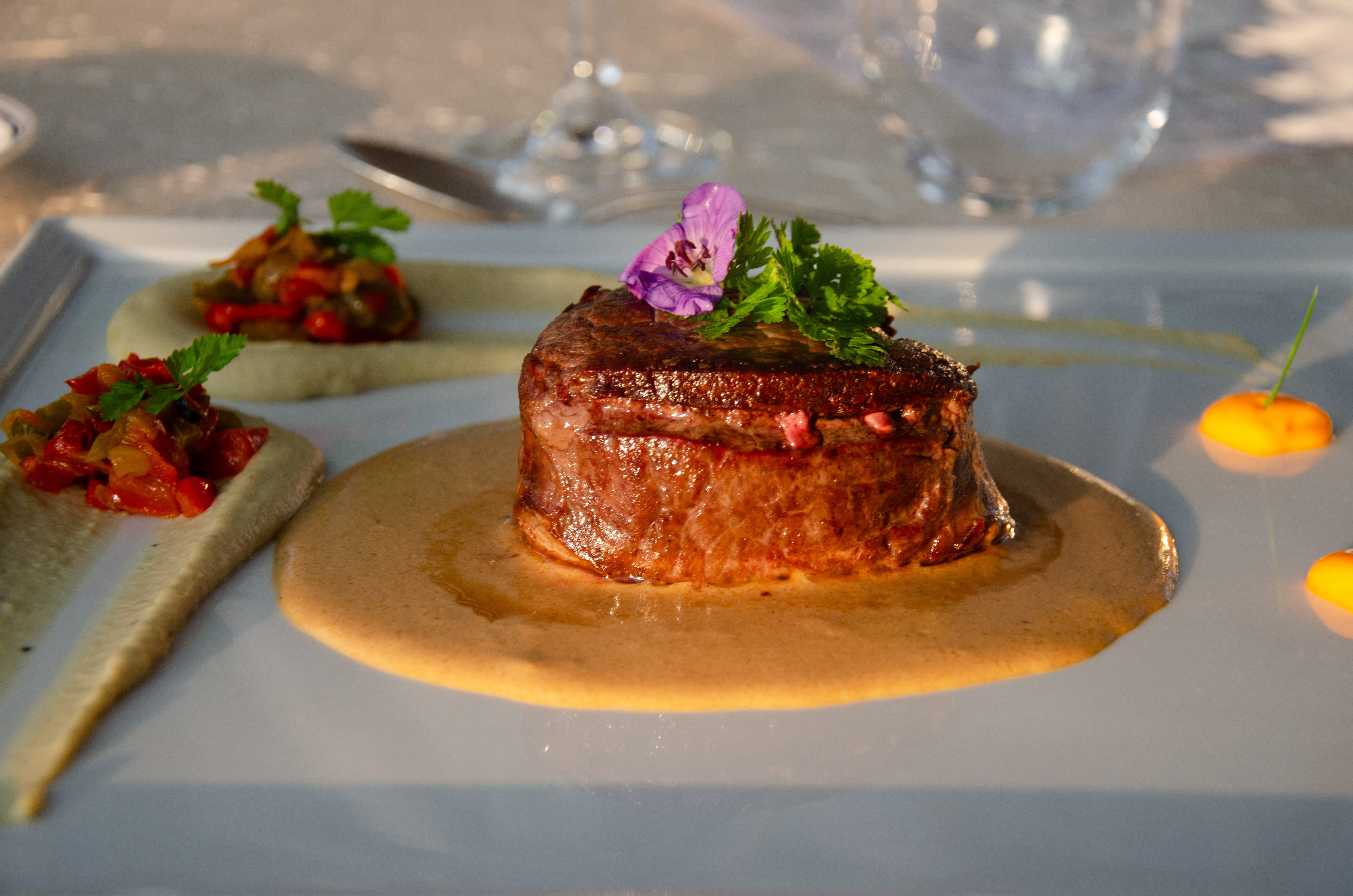 Assiette gastronomique avec viande et une fleur décorative